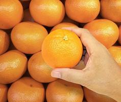 hand met oranje fruit op achtergrond oranje fruit foto