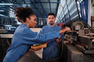 multiraciale professionele industriële ingenieursteams in veiligheidsuniformen werken door de spanningsstroom van machines te inspecteren, te controleren en te onderhouden in de fabrieksfabriek, elektrische systeemserviceberoepen. foto