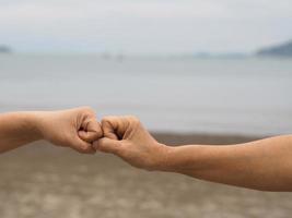 twee vrouwen alternatieve handdrukken vuist gebalde hand groet in de situatie van een epidemie covid 19, coronavirus nieuwe normale sociale afstand foto