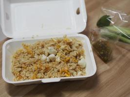 krabvlees gebakken rijst gegarneerd met roerei, stijl Thais eten, in witte schuimdoos foto
