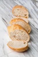 vers gesneden stokbrood brood op marmeren tafel. foto