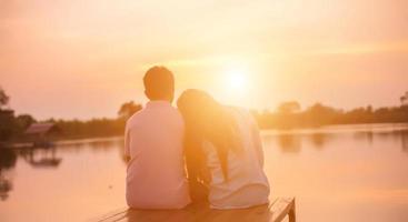 een silhouet van een man en vrouw hand in hand met elkaar, samen wandelen. foto