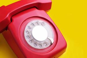 rode retro telefoon op gele achtergrond foto