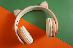 roze en witte koptelefoon op gekleurde achtergrond. muziek concept. foto
