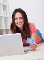 glimlachende vrouw die online winkelt foto