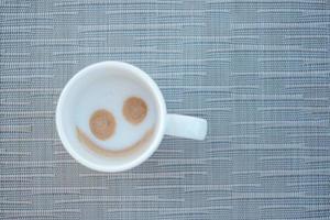 glimlach gezichtsvorm van warme cappuccino koffie. fijne dag concept foto