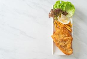 fish and chips - gebakken visfilet met aardappelchips foto