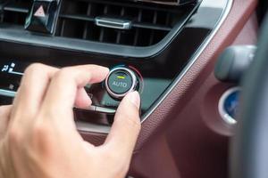 man hand temperatuur aanpassen de lucht stroomt tijdens het rijden auto op de weg, airconditioner koelsysteem in de auto. aanpassen, temperatuur en transportconcept foto