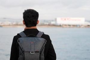 gelukkige man in jas en camera, Aziatische reiziger geniet van en uitzicht op de bezienswaardigheden in het schip foto