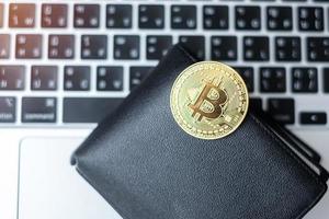 gouden cryptocurrency en portemonnee op toetsenbordlaptop, bitcoin-munt. crypto is digitaal geld binnen het blockchain-netwerk foto