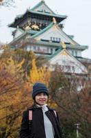 solo-vrouw die in het herfstseizoen naar het kasteel van osaka reist, bezoek van een Aziatische reiziger in de stad osaka, japan. vakantie, bestemming en reisconcept foto