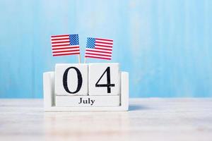 houten kalender van 4 juli met miniatuur vlag van de Verenigde Staten van Amerika op hout achtergrond. onafhankelijkheidsdag en natievakantieconcept foto