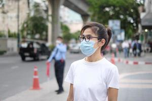 vrouw die medisch gezichtsmasker draagt tijdens het wandelen op straatvoetpad en avondmarkt, voorkom coronavirus of corona-virusziekte. gezondheid, levensconcept foto