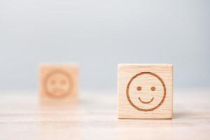 emotie gezicht symbool op houten blokken. servicebeoordeling, rangschikking, klantbeoordeling, tevredenheid, evaluatie en feedbackconcept foto