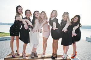 groep van 7 meisjes dragen op zwart en 2 bruiden op vrijgezellenfeest. foto