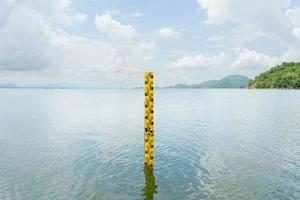 de gele schaal meet de hoogte van het water in de dam. het water in het stuwmeer is overvloedig en wordt gebruikt voor de landbouw en de consumptie van het dorp. Water reserveren natuur in thailand foto