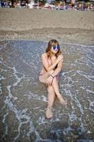 mooi model ontspannen op een strand gekleed in een zwembroek. foto