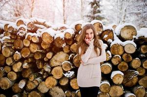 mooie brunette meisje in warme winterkleding. model op wintertrui in de buurt van stronk. foto