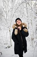 mooie brunette meisje in warme winterkleding. model op winterjas en zwarte hoed. foto