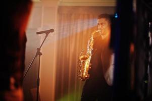 muzikale muziek live band die optreedt op een podium met verschillende lichten. saxofonist speelt. foto
