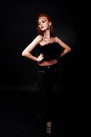 fashion model roodharige meisje met oorspronkelijk make-up als luipaard roofdier geïsoleerd op zwart. studio portret. foto
