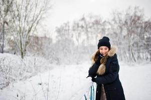 mooie brunette meisje in warme winterkleding. model op winterjas en zwarte hoed. foto