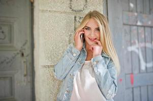 blond meisje slijtage op jeans jas gesteld op straat. foto