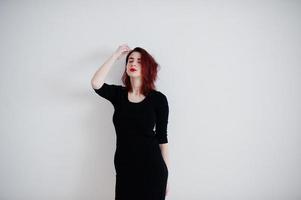 roodharige meisje op zwarte jurk tuniek tegen witte muur op lege kamer. foto