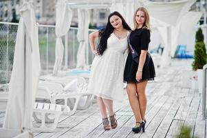 twee meisjes poseerden op vrijgezellenfeest op de pier van het strand. foto