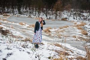 stijlvol meisje in leren jas op winterdag tegen bevroren meer. foto