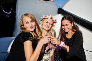 meisjes champagne drinken op jacht op vrijgezellenfeest. foto