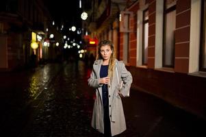 meisje met dreadlocks lopen 's nachts straat van de stad. foto