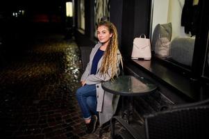 meisje met dreadlocks lopen 's nachts straat van de stad. foto