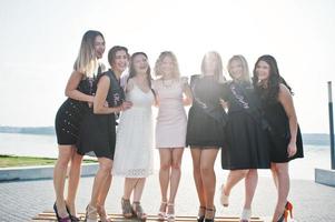 groep van 7 meisjes dragen op zwart en 2 bruiden op vrijgezellenfeest. foto