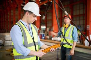 twee jonge ingenieurs die de werking van de semi-portaalkraan testen en controleren foto