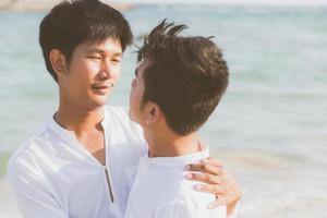homoseksueel portret jong aziatisch paar staande knuffel samen op het strand in de zomer, azië homo gaand toerisme voor vrije tijd en ontspannen met romantisch en geluk in vakantie op zee, lgbt-concept. foto