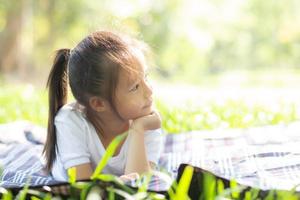 portret gezicht van schattig Aziatisch klein meisje en kind geluk en plezier in het park in de zomer, glimlach en gelukkig van Azië kind en ontspannen in de tuin, lifestyle jeugdconcept. foto