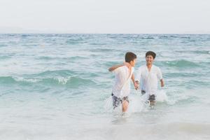 homoseksueel portret jonge aziatische paar lopen met vrolijk samen op het strand in de zomer, azië gay gaan toerisme voor vrije tijd en ontspannen met geluk in vakantie op zee, lgbt juridisch concept. foto