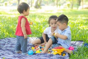 kleine jongen en meisje spelen voor idee en inspiratie met speelgoedblok, kind leren met bouwblok voor onderwijs, kinderactiviteit en spel in het park met gelukkig in de zomer. foto