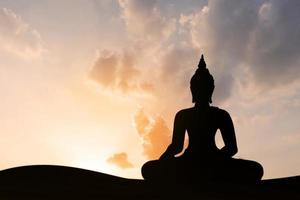 silhouet van boeddha bij zonsondergang foto