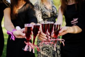 vijf meisjes dragen op zwart met ballonnen rode champagne drinken op vrijgezellenfeest. foto