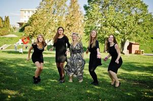 vijf meisjes dragen op zwart springen op vrijgezellenfeest. foto