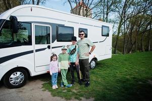 vader met drie kinderen reizen bij camper rv camper. foto