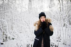 mooie brunette meisje in warme winterkleding. model op winterjas en zwarte hoed. foto
