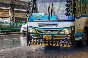 huai khwang bangkok thailand 2018 typische kleurrijke blauw ingerichte bus in zware regen bangkok thailand. foto