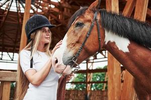 vrouwelijke jockey. gelukkige vrouw met haar paard overdag op de ranch foto