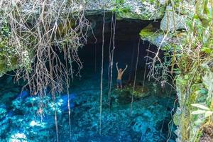 toeristische gids blauw turkoois water kalksteen grot sinkhole cenote mexico. foto