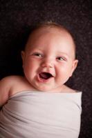 kleurenbeeld van glimlachende baby die vreedzaam op zwarte achtergrond ligt foto