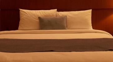 witte kussens en deken in bed met licht van lampen 's nachts foto