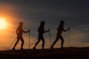 nordic walking in silhouet bij zonsondergang foto